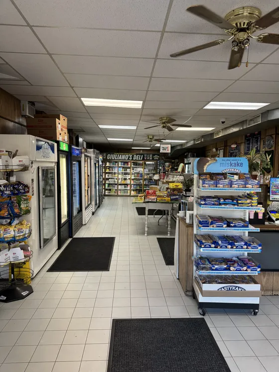 Inside the deli, looking down the aisle past the coolers to the counter