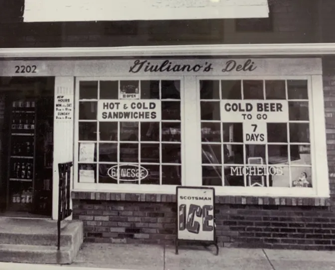 Giuliano's Deli storefront in its early years, advertising hot and cold sandwiches and cold beer to go