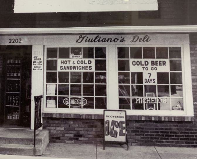 Giuliano's Deli storefront in its early years, advertising hot and cold sandwiches and cold beer to go